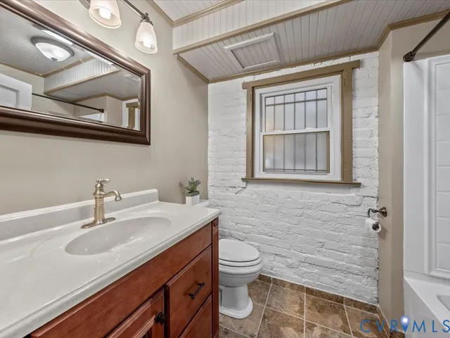 a bathroom with a sink a toilet and mirror