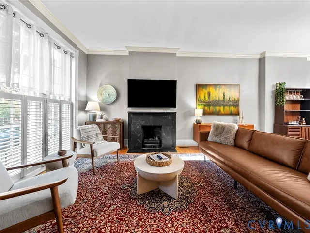 a living room with furniture a fireplace and a flat screen tv
