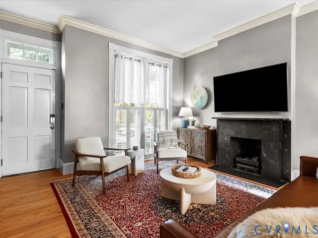a living room with furniture a flat screen tv and a fireplace