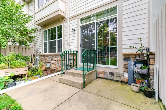 a view of a house with a floor to ceiling window and potted plants