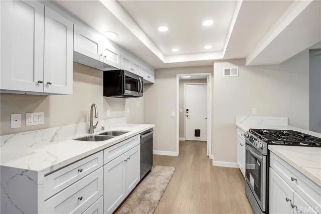 a kitchen with a sink stainless steel appliances and cabinets