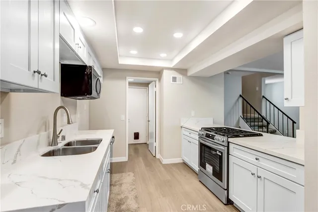 a kitchen with stainless steel appliances a sink a stove and a refrigerator