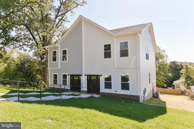 a view of a house with a yard and sitting area
