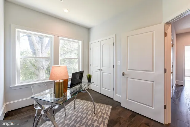a view of a workspace with furniture and a window