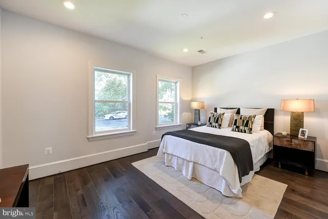 a spacious bedroom with a bed and wooden floor