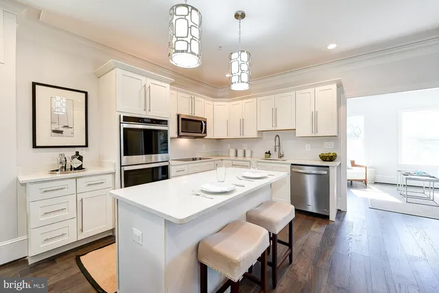 a kitchen with a center island appliances cabinets and furniture