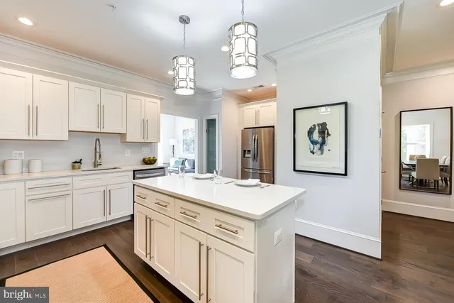 a view of a kitchen sink and dishwasher with white cabinets
