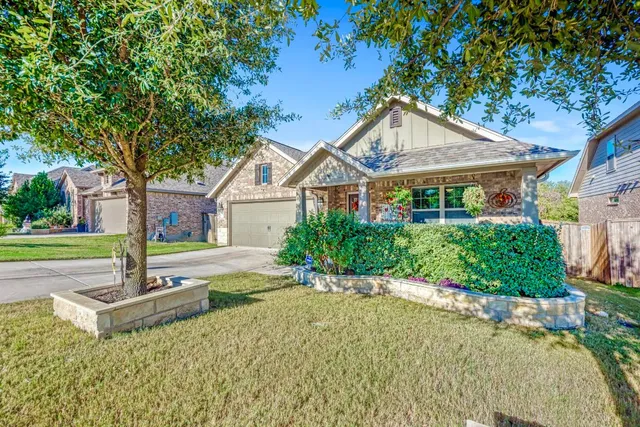 a front view of a house with a yard and potted plants