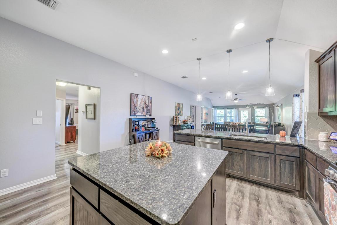 3101 Diego Cove Round Rock, TX 78665 - Photo 39 of 40 a kitchen with center island a sink stainless steel appliances wooden floor and cabinets
