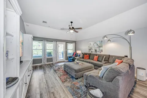 a kitchen with center island a sink stainless steel appliances wooden floor and cabinets