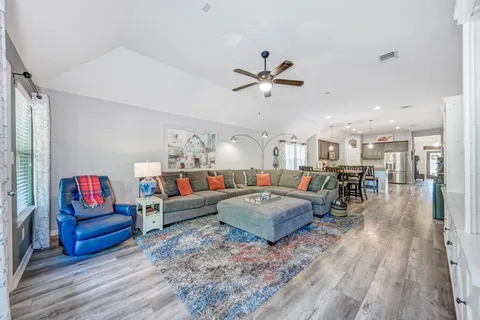 a living room with furniture and a wooden floor