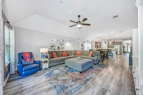 a living room with furniture and a wooden floor