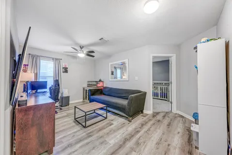 a living room with furniture ceiling fan and a flat screen tv