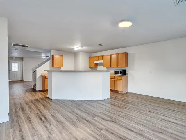 a kitchen with wooden floors and white cabinets