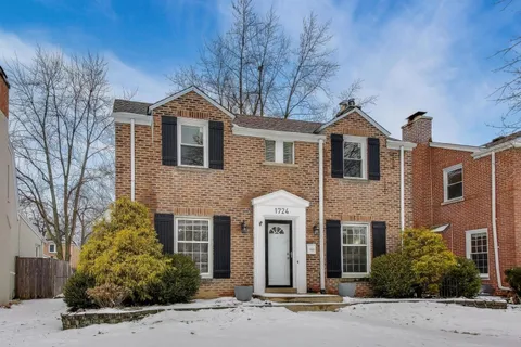 a front view of a house with yard and trees