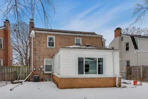 a white house that has a tree in front of it