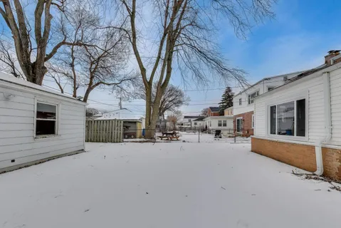 a front view of a house with large trees