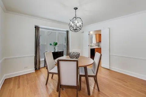 a dining room with furniture a chandelier and wooden floor
