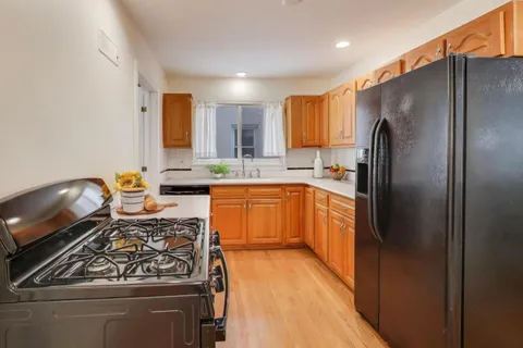 a kitchen with stainless steel appliances granite countertop a stove a sink dishwasher and a refrigerator