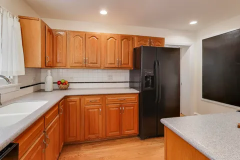 a kitchen with stainless steel appliances granite countertop a refrigerator and a sink