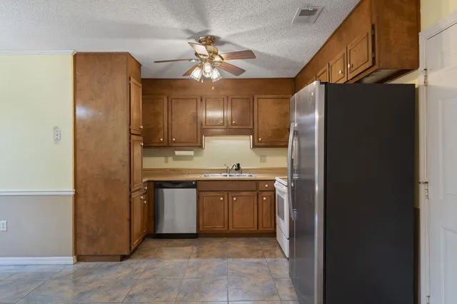 a kitchen with stainless steel appliances granite countertop a refrigerator a sink and dishwasher