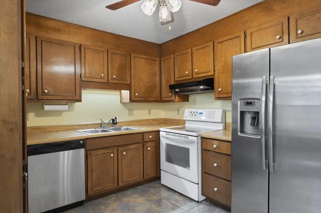 a kitchen with a refrigerator sink and cabinets