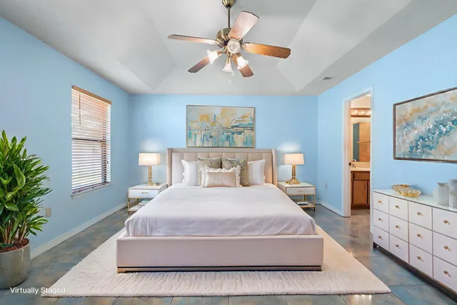 a bedroom with a large bed and a chandelier