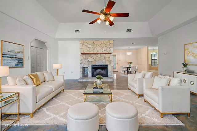 a living room with furniture a fireplace and a chandelier