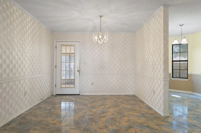 an empty room with windows and entryway