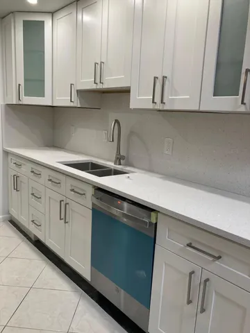 a kitchen with stainless steel appliances granite countertop white cabinets a sink and dishwasher