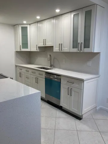 a kitchen with a sink cabinets and dining table chair