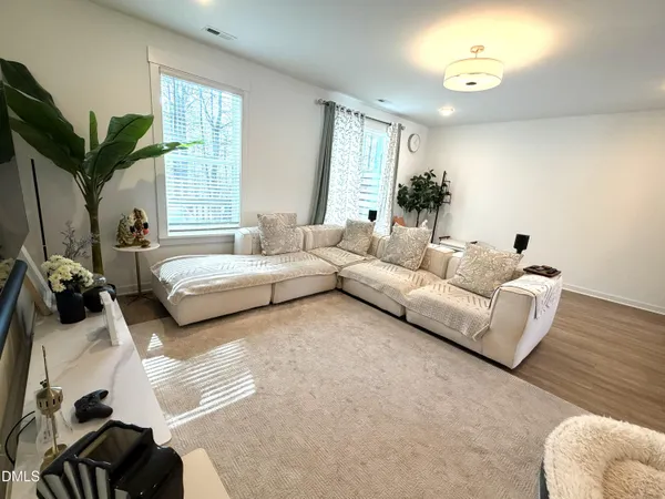 a living room with couches a coffee table and a large window with garden view