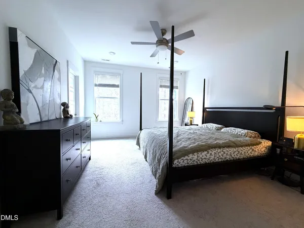 a bedroom with a large bed and a chandelier
