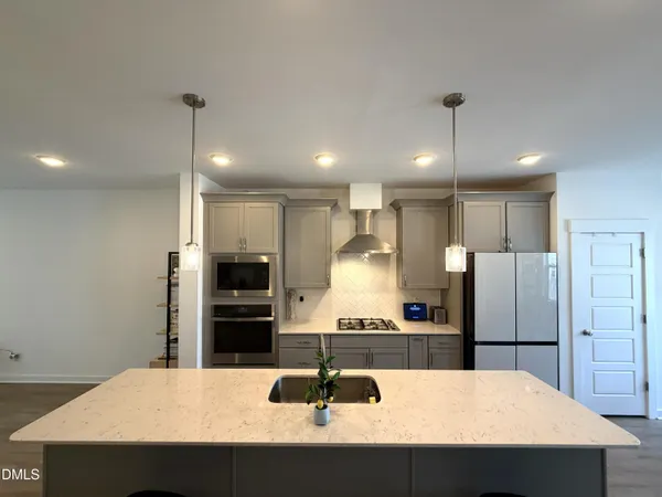 a kitchen with stainless steel appliances granite countertop a sink refrigerator and microwave