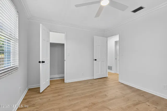 an empty room with closet and a chandelier fan