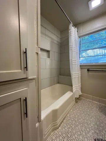 a bathroom with a bathtub and a shower