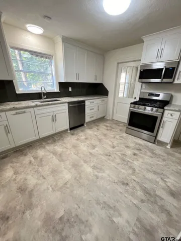 a kitchen with granite countertop a sink and cabinets