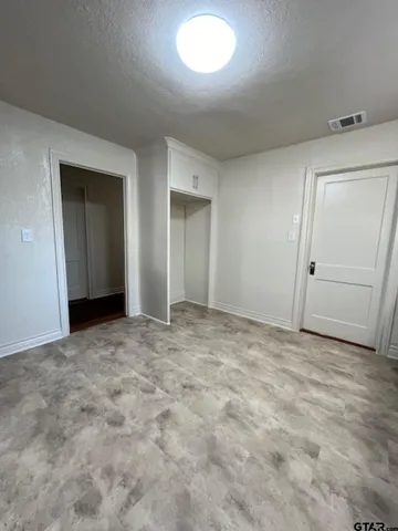 an empty room with closet and mirror