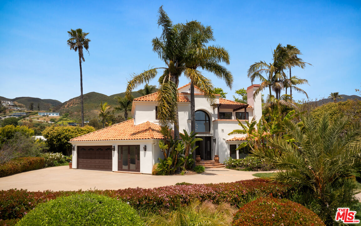 29675 Harvester Road Malibu, CA 90265 - Photo 2 of 36 a front view of a house with a yard and garage