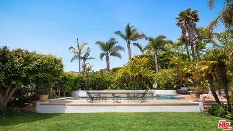 a view of house with swimming pool and trees in the background