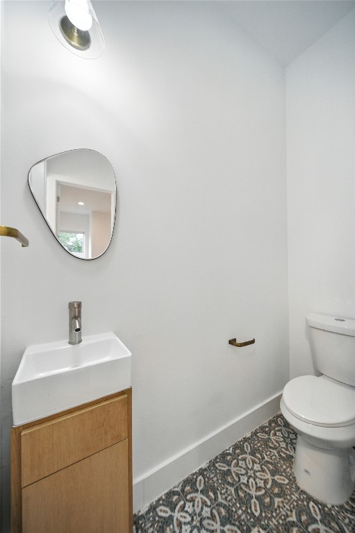 106 West Croslin Street, Unit B Austin, TX 78752 - Photo 9 of 23 a bathroom with a toilet a sink and mirror