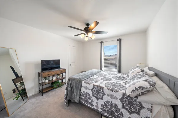 a bedroom with a bed and a flat tv screen on a dresser