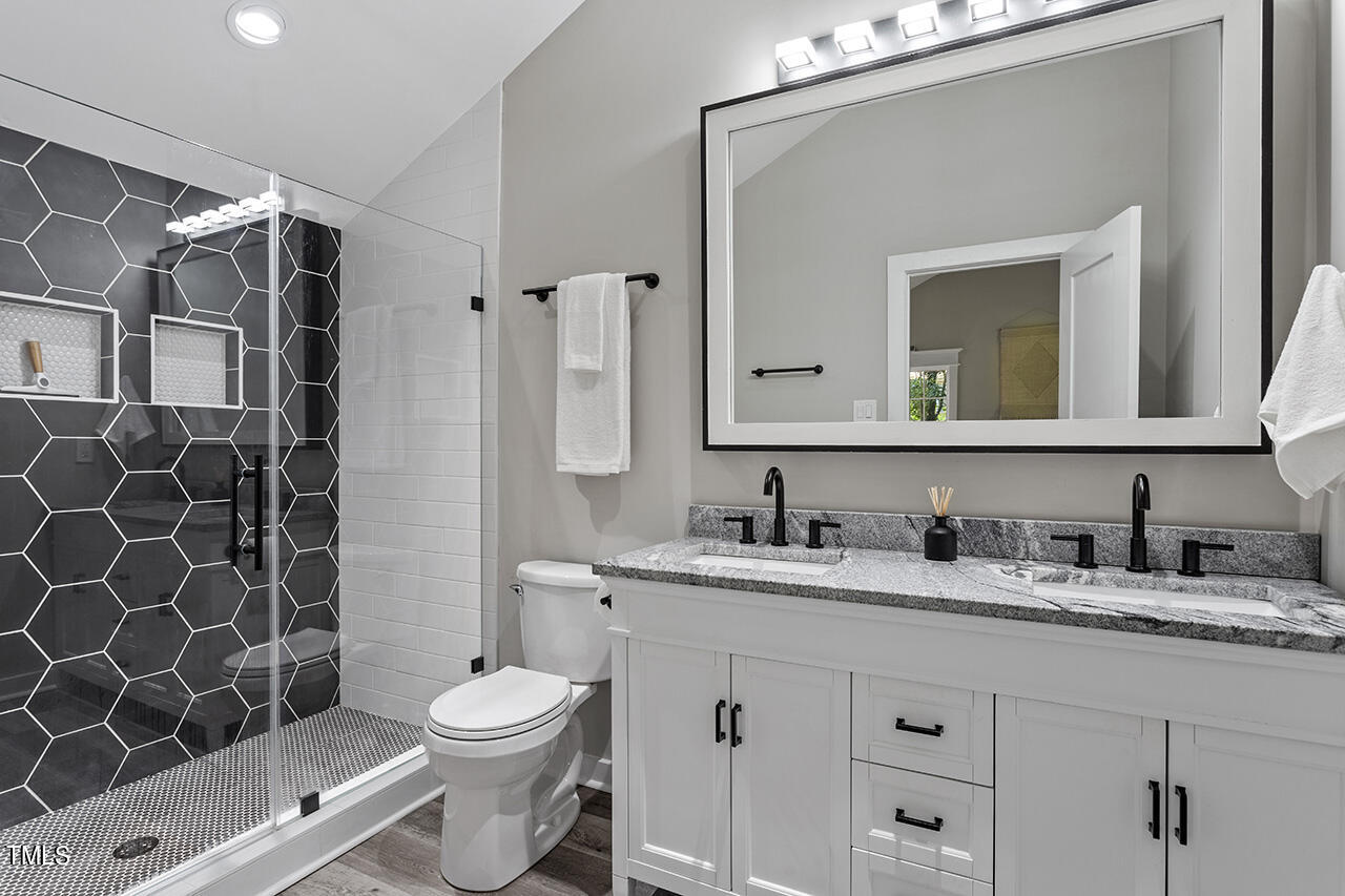 2241 Sheffield Road Raleigh, NC 27610 - Photo 19 of 33 a bathroom with a granite countertop sink toilet mirror and shower
