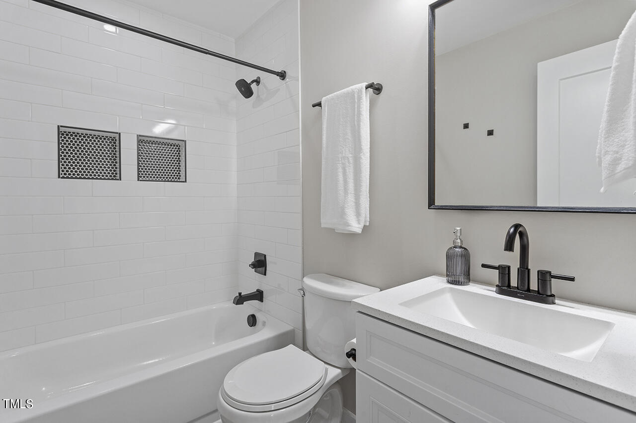 2241 Sheffield Road Raleigh, NC 27610 - Photo 24 of 33 a bathroom with a sink a toilet a mirror a bathtub and shower