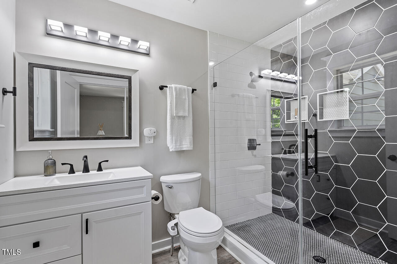 2241 Sheffield Road Raleigh, NC 27610 - Photo 25 of 33 a bathroom with a granite countertop sink a toilet and a mirror