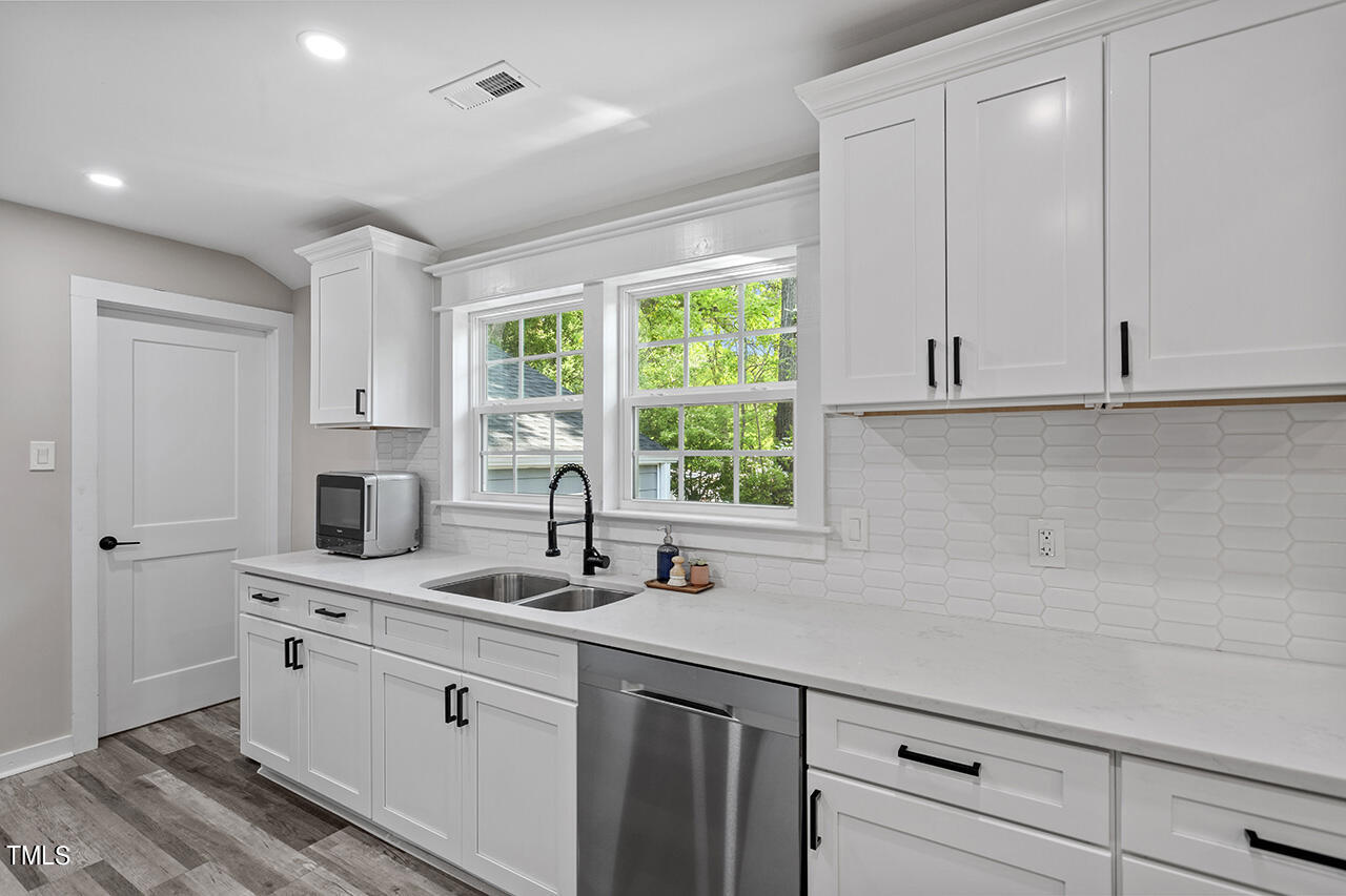 2241 Sheffield Road Raleigh, NC 27610 - Photo 3 of 33 a kitchen with stainless steel appliances white cabinets and a window