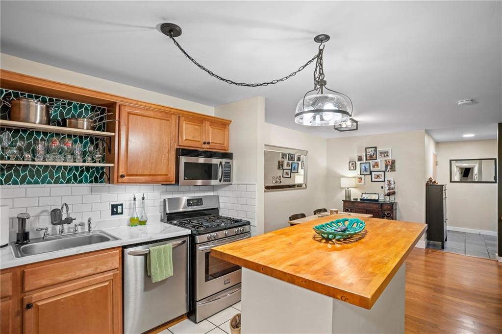 1706 Kenzie Road Pittsburgh, PA 15205 - Photo 11 of 25 a kitchen with stainless steel appliances granite countertop a sink a stove and a wooden floors