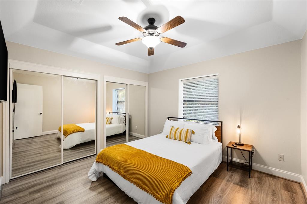 424 Windjammer Lane Azle, TX 76020 - Photo 18 of 37 Bedroom featuring multiple closets, wood finished floors, multiple windows, and ceiling fan