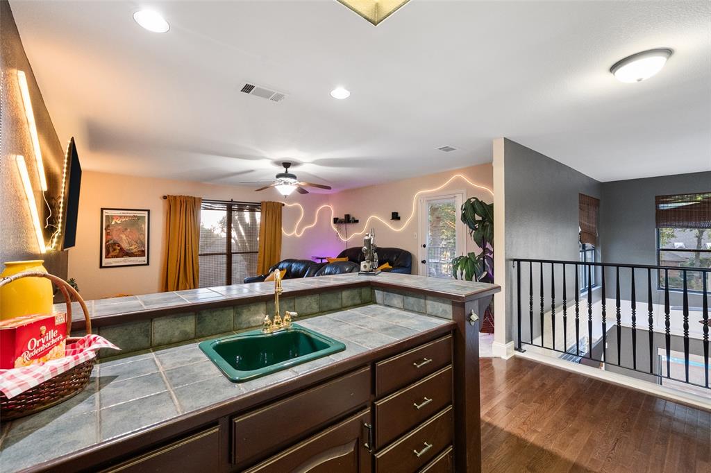 424 Windjammer Lane Azle, TX 76020 - Photo 37 of 37 Kitchen featuring tile counters, dark brown cabinets, dark wood finished floors, recessed lighting, and open floor plan