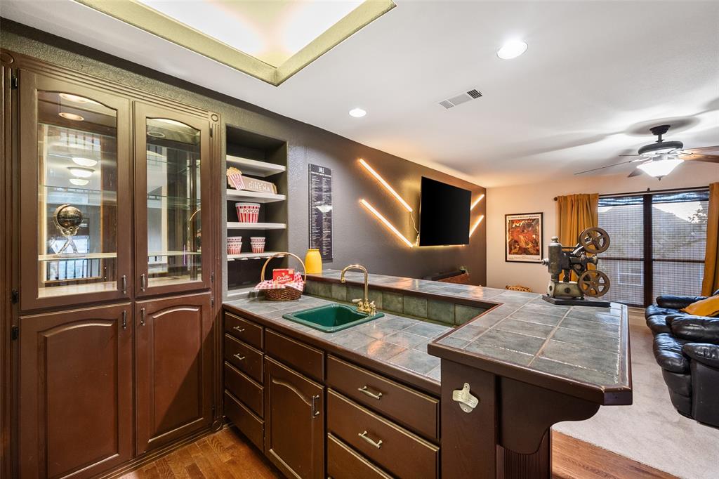 424 Windjammer Lane Azle, TX 76020 - Photo 21 of 37 Kitchen featuring recessed lighting, a breakfast bar area, a peninsula, open shelves, and glass insert cabinets